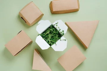 Fototapeten Eco-friendly paper food cases of different shapes and box full of geens © zzzdim