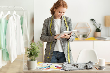 Fashion designer browsing new sketches collection on tablet