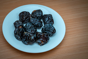 Ramadan food and drinks concept. Dates fruit in a bowl on wooden table background.