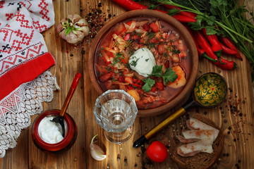 Borsch with sour cream, lard and vodka on a wooden table