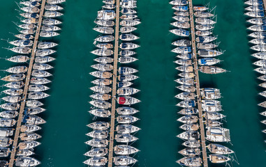 Croatia, marina Kastela, 15 September 2019: Drone view point on moored in an equal row sailboats, participant of a sailing regatta, piers, a lot of boats, mountains is on background, piers