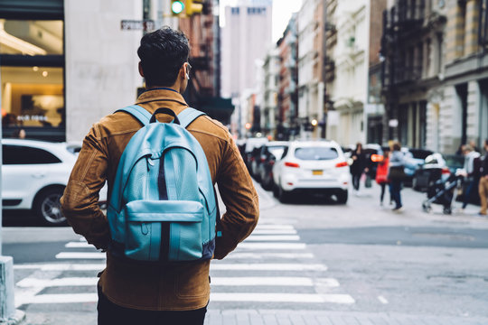 Man walking with backpack and earphones