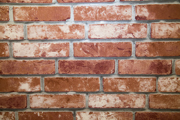 The background is made of artificial red and brown stone with a rectangular shape in the form of a wall made of burnt bricks. Backgrounds, textures, and design.