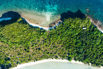 Aerial scenery of picturesque island with crystal azure water and green vegetation.Bird's eye view of paradise beach shoreline, beautiful tourist destination for summer vacations, sport attractions