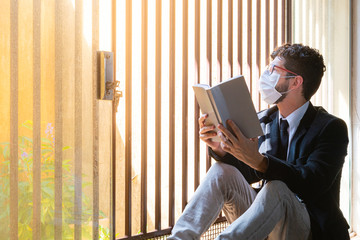 Businessman in his residence during social distance reading book to relax.