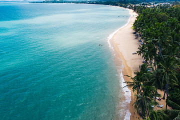 Fototapeta na wymiar Aerial scenery view of white sand beach shore with turquoise clear sea water and foamy waves. Bird's eye panoramic view of picturesque coastline bay. Samui island, Thailand