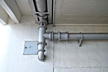 Large diameter gray plumbing tubes in a typical industrial installation.