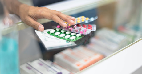Female preparing medicine capsule pack  pharmacy to sell to patient for protect at the drug store.