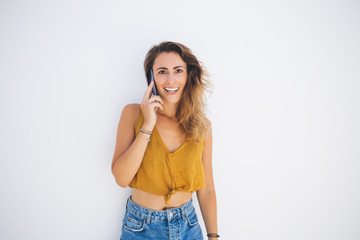 Fototapeta premium Excited woman with smartphone smiling at wall