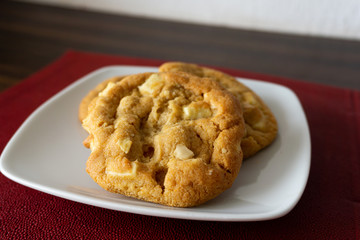 Tasty macadamia and white chocolate cookies on a plate