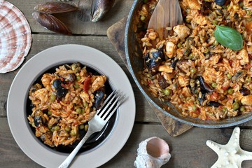 orzo pasta with mussels, seashells and chicken. Seafood paella, traditional spanish dish. Paella on rustic black wooden table. Top view