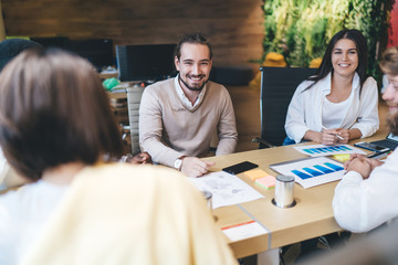 Portrait of successful Caucasian male and female traders discussing analytic report enjoying cooperation in office, group of cheerful financial experts analyzing revenue monetary gain at desktop