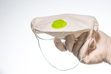 Hand holding medical mask on white background
