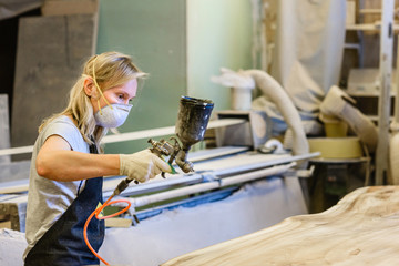 A woman in a work uniform working at the factory or workshop. The concept of women's equality and feminism. Female carpenter.