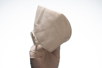 Hand holding medical mask on white background