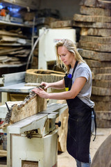 A woman in a work uniform working at the factory or workshop. The concept of women's equality and feminism. Female carpenter.