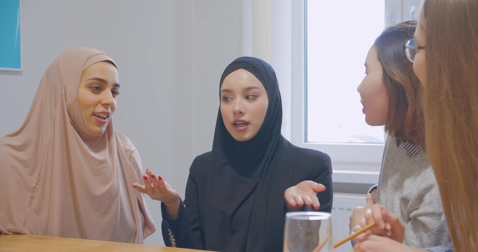 Three office communication break colleagues use an smartphone diverse multiraces happy joke hijab asian