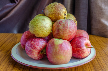 Apples and pears stacked on a plate