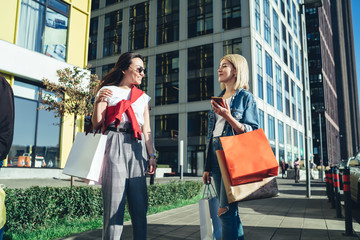 Positive shopaholics after shopping against urban background