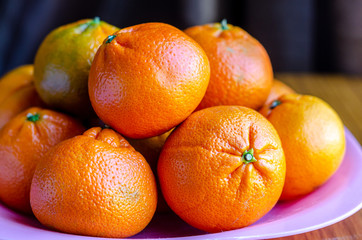 Mandarin oranges piled up on a plate.