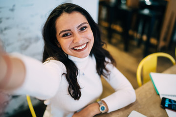 Close up selfie portrait of cheerful hipster girl with perfect toothy smile on face,happy Caucasian...