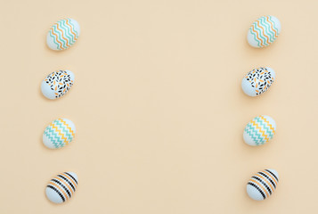 Decorated Easter eggs lie on the yellow background. Happy Easter holiday and minimalism concept. Greeting, invitation card. Flat lay style with copy space.