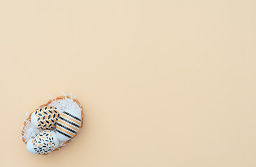 Decorated Easter eggs lie in the basket on yellow background. Happy Easter holiday concept. Greeting, invitation card. Flat lay style with copy space.