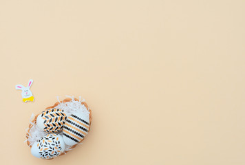 Decorated Easter eggs lie in the basket on yellow background with Easter bunny. Happy Easter...