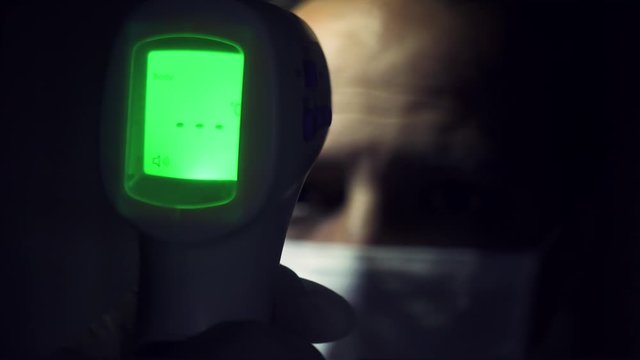 Infrared thermometer measuring a man's dangerously high body temperature