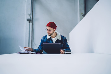 Cheerful male working with papers and tablet