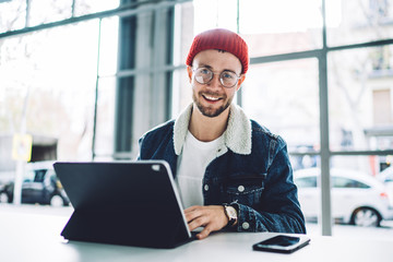 Cheerful young male freelancer looking at camera
