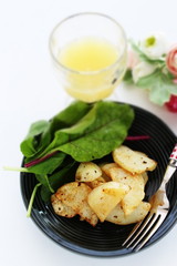 Potato and anchovy stir fried served with baby leaves