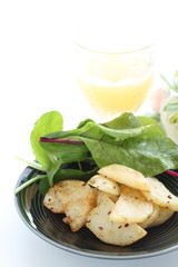 Potato and anchovy stir fried served with baby leaves