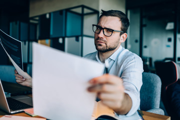 Discontented businessman working with documents in office