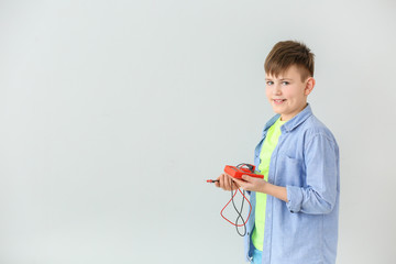 Cute little schoolboy with tester on grey background
