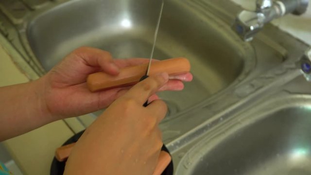 Lady hand slices fresh sausage