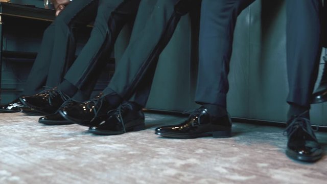 Legs of men, stylish black shoes of groom and his best men, man fashion, footwear of businessmen in luxury room