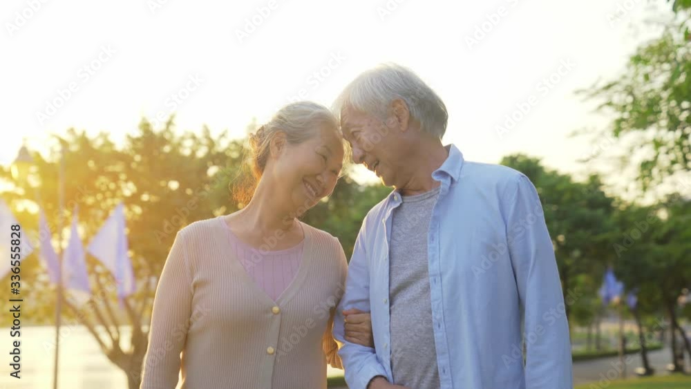 Wall mural loving old asian couple walking talking outdoors in park