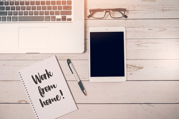 Flat lay concept to work from home during the spread of pandemic Covid-19 and Coronavirus on modern workspace desk with laptop, notepad, pen, spectacle eyeglass and tablet pc. Top view.