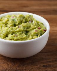 Tigela com Guacamole sobre mesa de madeira