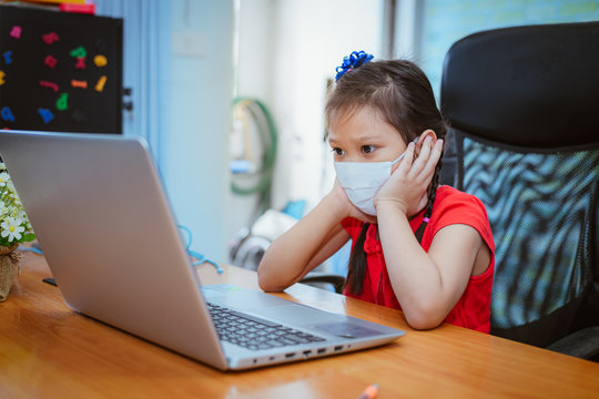 Asian girl with online education. littel girl wear medical mask studying at home, working at laptop notebook with special teacher exercise in coronavirus quarantine.