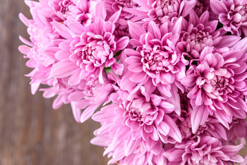 Close up of bouquet of pink chrysanthemums, wood table as background
