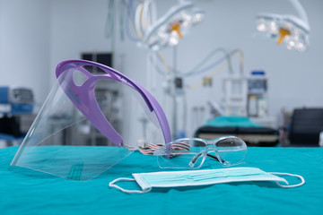 Group of protective headwear for Doctor and Nurse (such as surgical mask, face shield and safety glasses) before surgery in operating room. Conceptual of important objects in covid-19 outbreak.