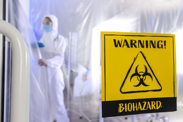 Biohazard warning sign on door of contagious isolation ward. Concept of Coronavirus epidemic