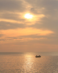 Fototapeta na wymiar Barca sobre el reflejo del sol en el mar