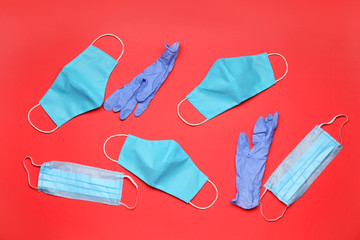Medical masks and gloves on color background