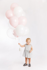 Little cute girl hold menu pink and white balloons enjoy festive  birthday event wear grey pastel summer dress rabbit-footwear isolated on a white background.