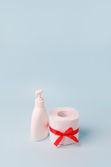 Set of toilet paper roll and liquid soap or sanitizer wrapped in gift bow. The concept valuable actual gift, a meme on the deficit in supermarkets, coronavirus covid-19, panic, excitement and shortage