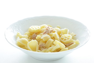 Prepared pasta and tuna salad in white bowl on white background