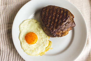 fried egg and steak on white plate